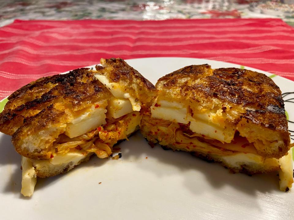 The grilled cheese cut in half and displayed on a plate.