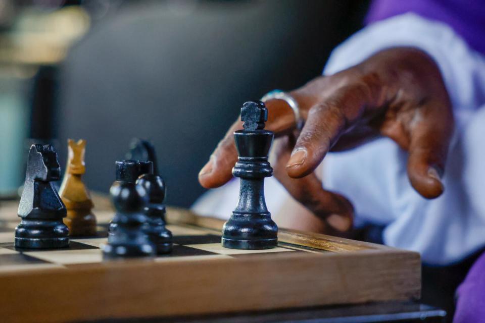 Vincent Hubbard's hand reaches for a chess piece.