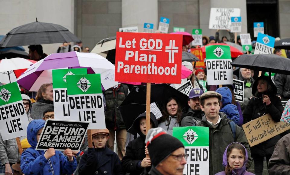 People taking part in an anti-abortion march hold signs as they stand on the steps of the Legislative building, Tuesday, Jan. 22, 2019, at the Capitol in Olympia, Wash. The event was part of annual “March for Life” events held in other states and Washington, DC, near the Jan. 22, 1973 anniversary of the Supreme Court’s Roe v. Wade decision, which legalized abortion. (AP Photo/Ted S. Warren)