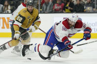 Montreal Canadiens defenseman David Savard (58) knocks the puck up the ice against Vegas Golden Knights center Michael Amadio (22) during the second period of an NHL hockey game Thursday, Jan. 20, 2022, in Las Vegas. (AP Photo/John Locher)