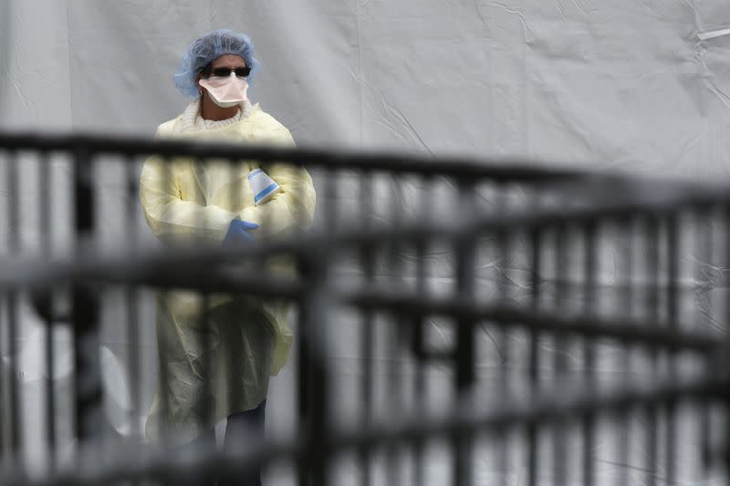 A Hospital worker waits for people wanting to be tested for coronavirus disease (COVID-19) outside Elmhurst Hospital Center in New York