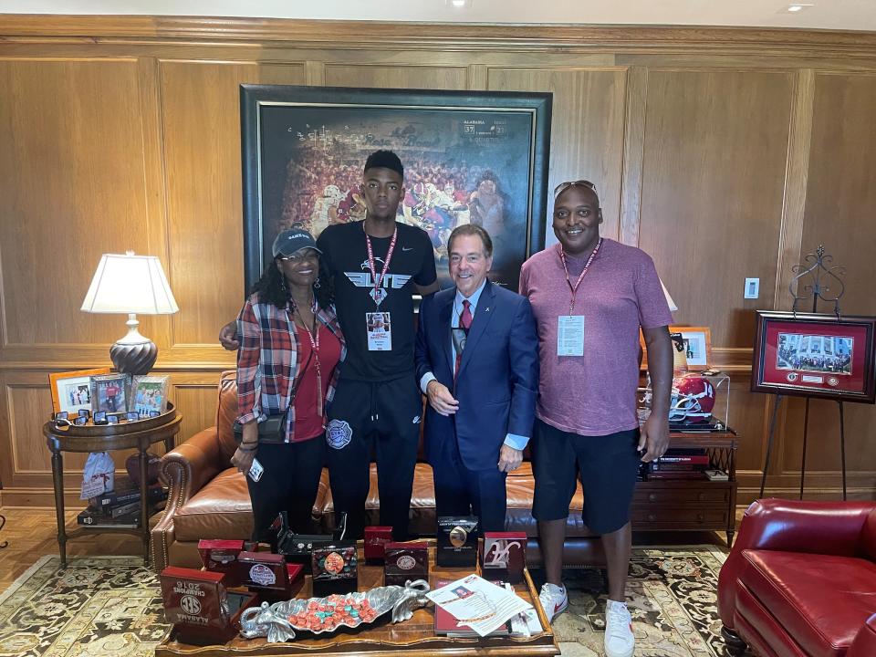 Brandon Miller and Nick Saban stand with Miller's parents during one of his recruiting visits.