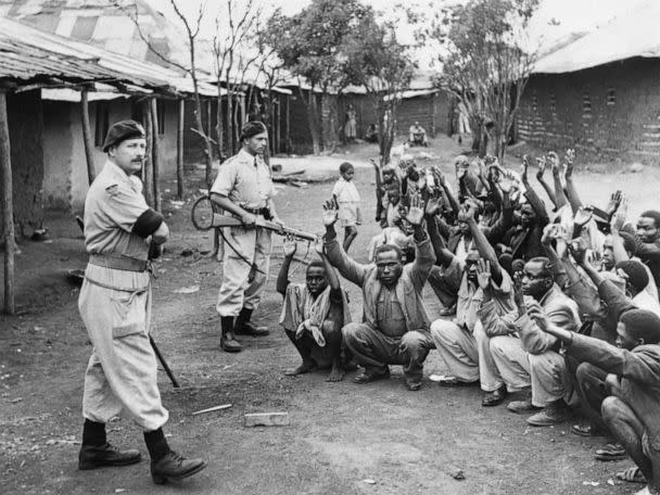 PHOTO: British policemen hold men from the village of Kariobangi at gunpoint while their huts are searched for evidence that they participated in the Mau Mau Rebellion of 1952. (Bettmann Archive via Getty Images)