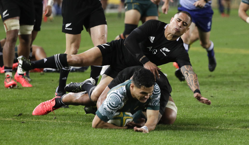 Australia's Noah Lolesio, bottom, scores his team's first try as New Zealand's Aaron Smith attempts a tackle during the Bledisloe rugby test between the All Blacks and the Wallabies at Stadium Australia, Sydney, Australia, Saturday, Oct. 31, 2020. (AP Photo/Rick Rycroft)