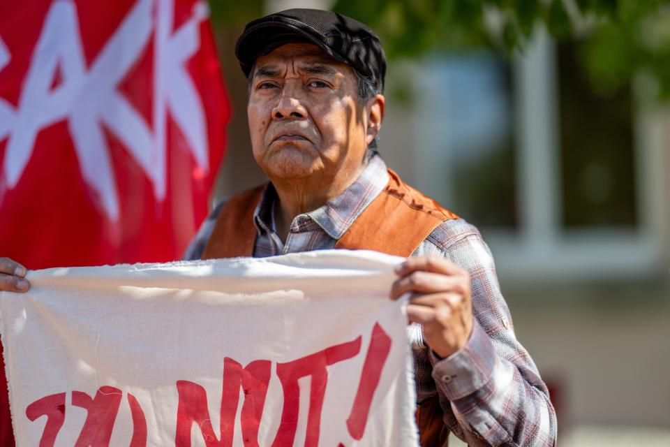 A person stands in protest against the reinstallation of a 16th-century New Mexico conquistador statue at the Rio Arriba County building on 28 September 2023 (Getty Images)