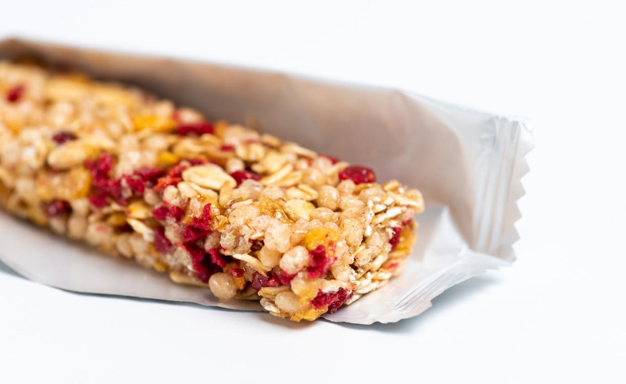 Protein energy bar with wholegrain cereals and berry fruit on white background isolated closeup