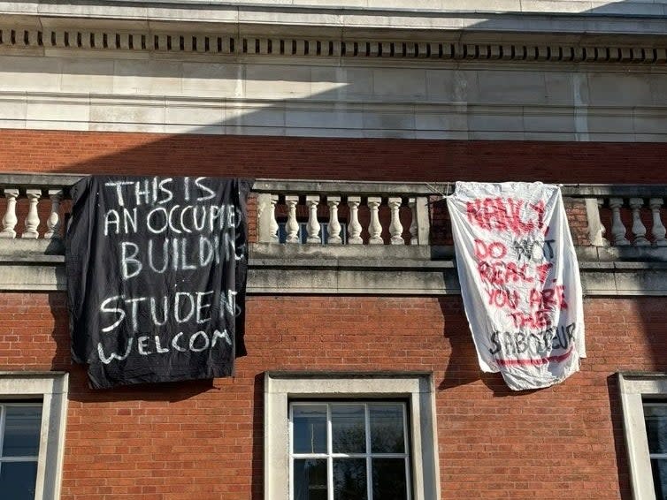 Students at the University of Manchester hang flags out of an occupied building on campus (Supplied)