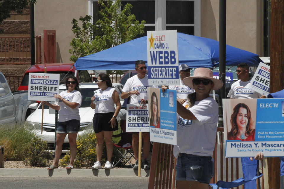 Voters drive through a gauntlet of political picket signs at a primary election polling site in Santa Fe, N.M., on Tuesday, June 7, 2022. Republican voters are choosing a nominee for New Mexico governor from a field of five candidates. The winner of Tuesday's GOP contest will take on incumbent Democratic Gov. Michelle Lujan Grisham. Democratic voters are deciding on a nominee for the top law enforcement post as Attorney General Hector Balderas terms out of office, amid a long list of local races. (AP Photo/Morgan Lee)