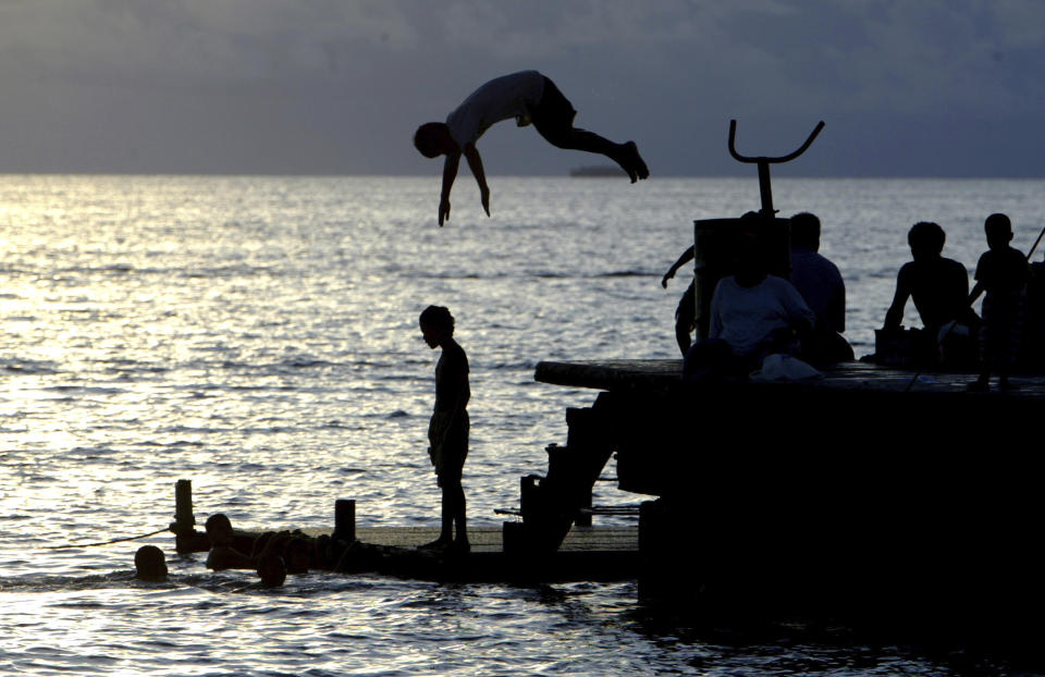 FILE - Children play in the lagoon near Funafuti, Tuvalu, March 24, 2004. On Friday, Jan 26, 2024, the small Pacific island of Tuvalu head to the polls to select representatives for its 16-seat parliament. (AP Photo/Richard Vogel, File)