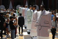 Guests take pictures of model at the Thom Browne mens Spring-Summer 2020 fashion collection presented in Paris, Saturday, June 22 2019. (AP Photo/Michel Euler)