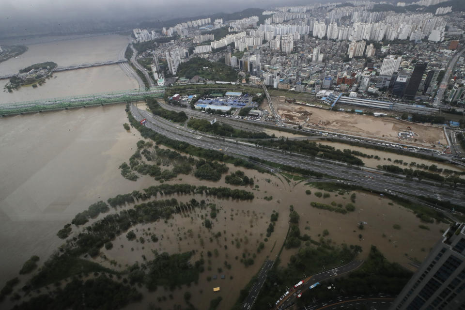 A part of a main road and a park near the Han River are flooded due to heavy rain in Seoul, South Korea, Thursday, Aug. 6, 2020. Torrential rains continuously pounded South Korea on Thursday, prompting authorities to close parts of highways and issue a rare flood alert near a key river bridge in Seoul. (AP Photo/Lee Jin-man)