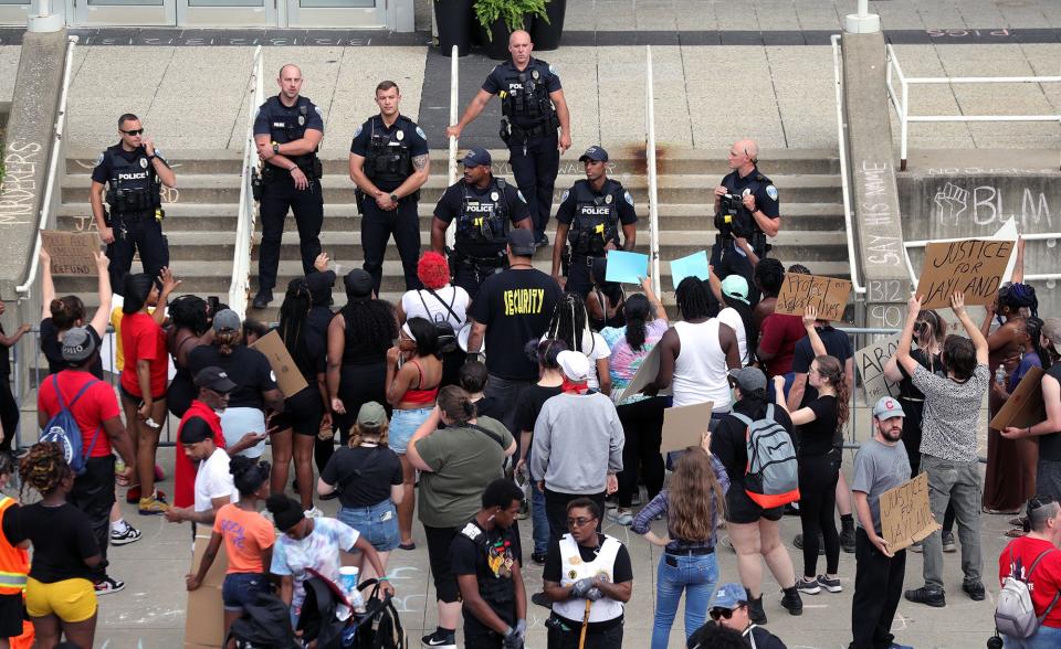 Police officers keep a watchful eye on a group protesting the death of Jayland Walker on July 2, 2022, in Akron, Ohio.