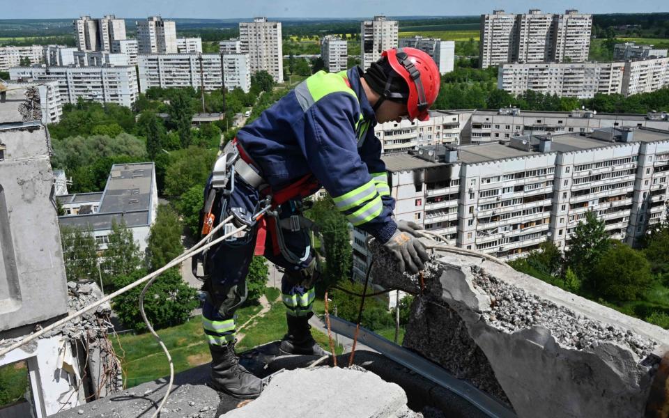 Rescuers dismantle the collapsing structure of a heavily damaged 16-storey residential building in the Saltivka district, northern Kharkiv - SERGEY BOBOK/AFP