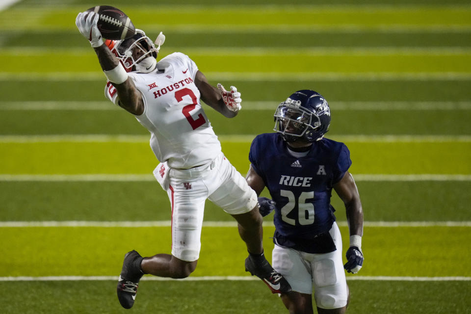 Houston wide receiver Matthew Golden (2) catches a pass as Rice safety Gabriel Taylor (26) defends during the second half of an NCAA college football game Saturday, Sept. 9, 2023, in Houston. (AP Photo/Eric Christian Smith)