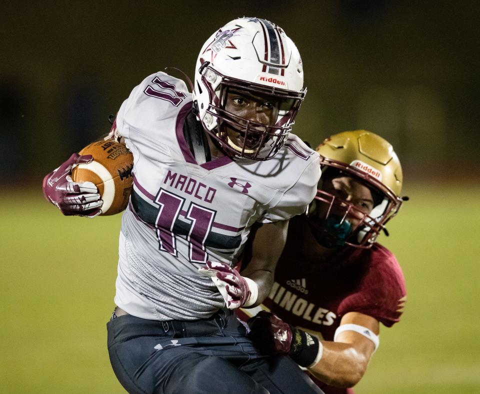 Madison County wide receiver John Christian (11) looks towards the end zone as he tries to outrun a tackle. The Florida High Seminoles defeated the Madison County Cowboys 21-6 Friday, Sept 23, 2022.