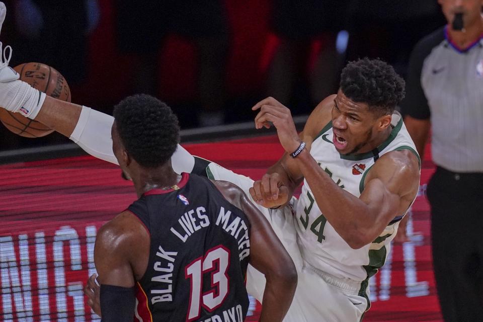 Milwaukee Bucks' Giannis Antetokounmpo dunks over Miami Heat's Bam Adebayo during the first half of an NBA conference semifinal playoff basketball game Sunday, Sept. 6, 2020, in Lake Buena Vista, Fla. (AP Photo/Mark J. Terrill)