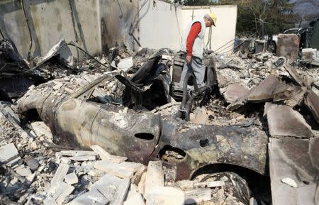 Dan Mufson searches through the remains of his home of 20 years after it was destroyed by a wildfire in Napa. REUTERS/Jim Urquhart