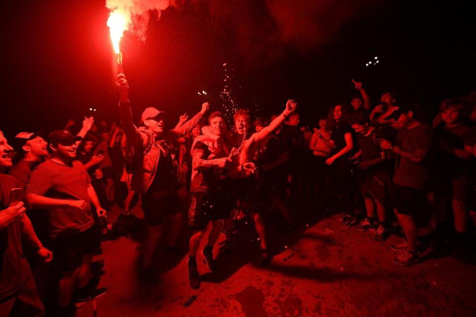 Fans celebrate Liverpool winning the Premier League title outside Anfield stadium.