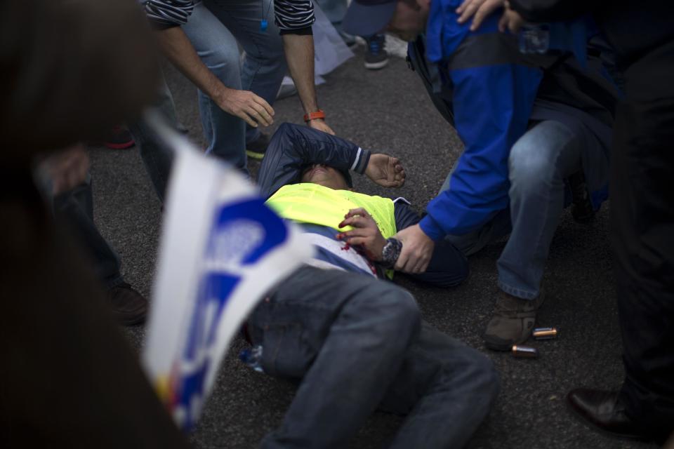 A demonstrating police officer lies on the ground after a firework he was set to throw exploded on his hand during a protest in front of the Interior Ministry in Madrid, Spain, Saturday, Oct. 27, 2012. About 3,000 off-duty police officers are demonstrating in Madrid to protest the government's austerity measures, including the cancellation of their Christmas bonuses. (AP Photo/Emilio Morenatti)