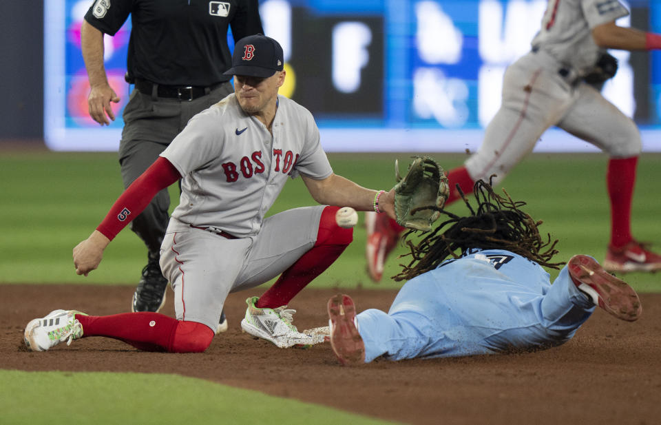 Toronto Blue Jays Vladimir Guerrero Jr. slides in under the glove of Boston Red Sox second baseman Enrique Hernandez to steal second base during the third inning of a baseball game in Toronto, Sunday, July 2, 2023. (Frank Gunn/The Canadian Press via AP)