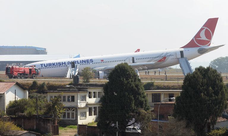 Rescue workers check the area around a Turkish Airlines plane after it missed the runway at Kathmandu's international airport on March 4, 2015