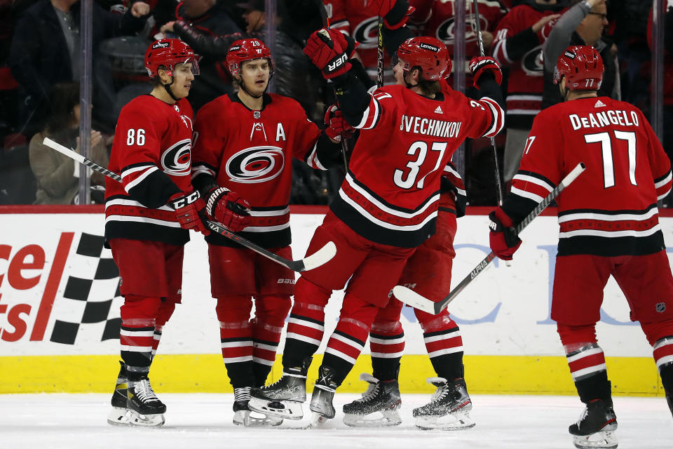 Carolina Hurricanes' Sebastian Aho, second left, celebrates his goal with teammates Teuvo Teravainen (86), Andrei Svechnikov (37), Vincent Trocheck, back, and Tony DeAngelo (77) during the first period of an NHL hockey game against the Vancouver Canucks in Raleigh, N.C., Saturday, Jan. 15, 2022. (AP Photo/Karl B DeBlaker)