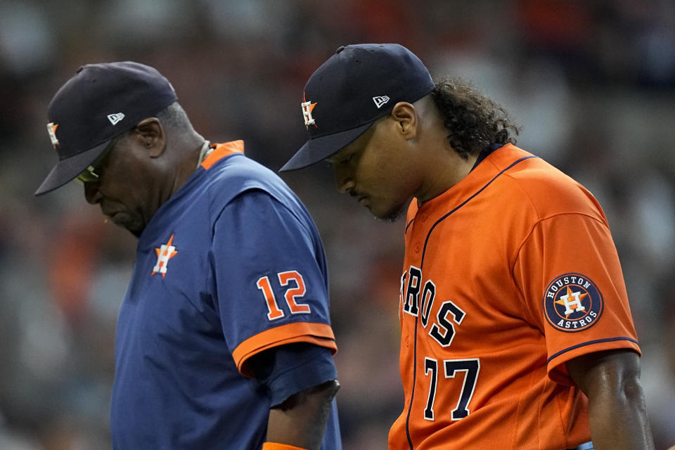 Houston Astros starting pitcher Luis Garcia leaves the games with manager Dusty Baker Jr. against the Boston Red Sox during the second inning in Game 2 of baseball's American League Championship Series Saturday, Oct. 16, 2021, in Houston. (AP Photo/David J. Phillip)