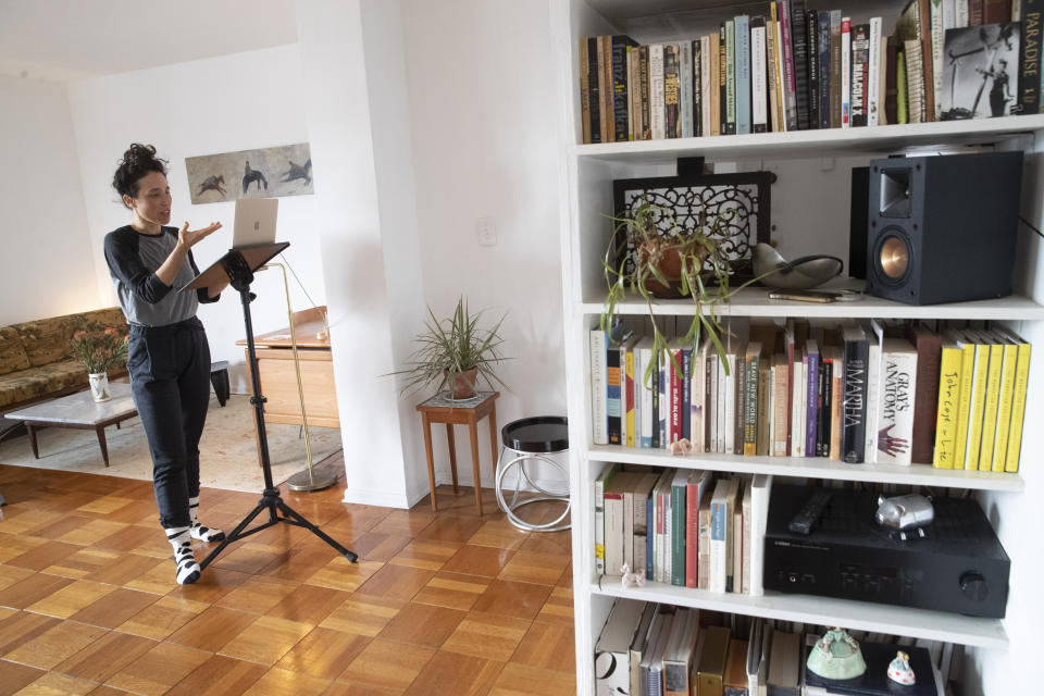 FILE - In this Thursday, April 23, 2020, photo dancer choreographer Netta Yerushalmy speaks to the other participants on her computer during a Zoom meeting dance rehearsal in her living room on the Lower East Side neighborhood of New York. Many artists like Yerushalmy have turned to social media to get their work out during the coronavirus pandemic, posting music and artwork on Instagram. (AP Photo/Mary Altaffer)