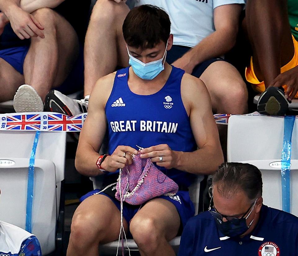 Tom Daley of Great Britain knits as he watches the Women's 3m Springboard Final on day nine of the Tokyo 2020 Olympic Games at Tokyo Aquatics Centre on August 01, 2021 in Tokyo, Japan.