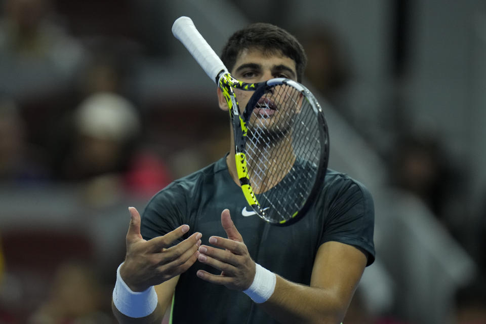 Carlos Alcaraz of Spain throws his racquet after losing a point to Jannik Sinner of Italy during the men's singles semifinal match in the China Open tennis tournament at the Diamond Court in Beijing, Tuesday, Oct. 3, 2023. (AP Photo/Andy Wong)