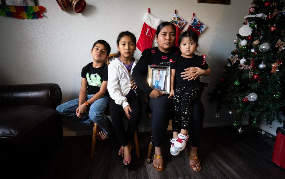 Emmanuel Pop Ba's wife, Domitilia Caal Pop, second from right, sits Thursday with her daughters, Camila, 3, right, and Adriana, 7, and with Emmanuel's adopted son, Esteban Pop Caal, 9, left, at the family's home in North Austin. Emmanuel, 32, was killed in Tuesday's shooting rampage that left four dead in Austin.