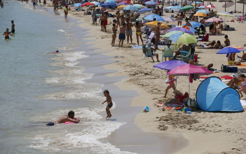 People sunbathe at Magaluf beach in Mallorca