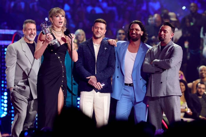 taylor swift accepting her award with n'sync behind her on stage