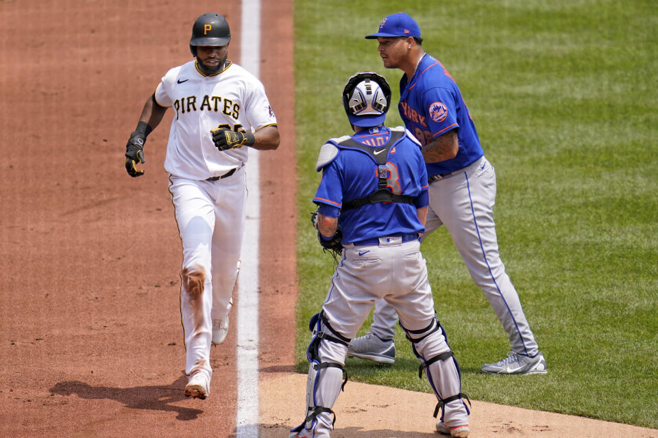 Pittsburgh Pirates' Gregory Polanco, left, scores past New York Mets starting pitcher Taijuan Walker, right, and catcher Tomas Nido on an infield hit by Kevin Newman and a fielding error during the first inning of a baseball game in Pittsburgh, Sunday, July 18, 2021. Three runs scored on the fielding error by Walker. (AP Photo/Gene J. Puskar)