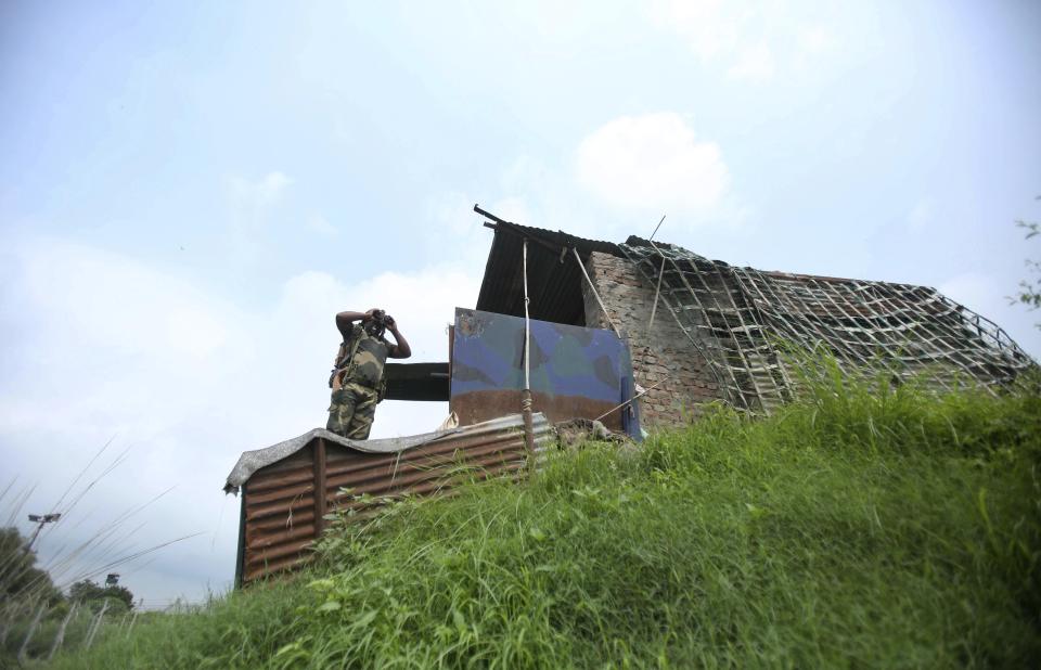 In this Tuesday, Aug. 13, 2019 file photo, An Indian Border Security Force (BSF) soldier keeps vigil near the India Pakistan border in Akhnoor, about 35 kilometers (22 miles) west of Jammu, India. Pakistan's prime minister assured Kashmiri people living in the Indian-administered part of the divided region that he supports them in their struggle for self-determination. In his statement Wednesday, Imran Khan condemned New Delhi's decision Aug. 5 to downgrade Kashmir's status, as he began celebrations marking Pakistan's independence day.(AP Photo/Channi Anand)