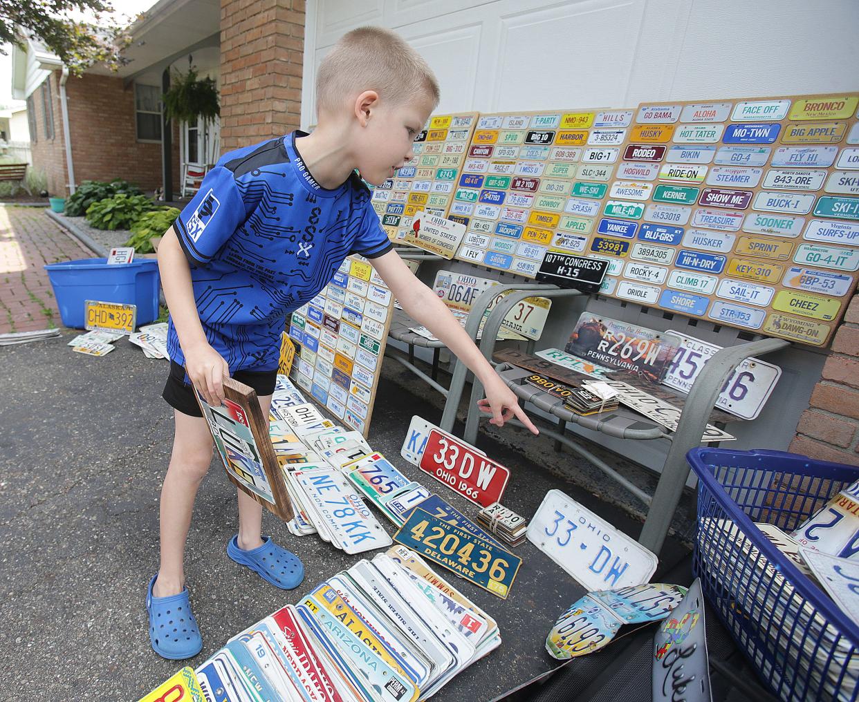 Luke Reicosky, 7, shows off dozens of his new  license plates Wednesday at his home in Brewster. Luke has received numerous plates in the mail or via special delivery since a news story ran June 21 about his collection.