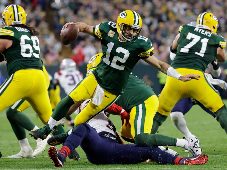 Aaron Rodgers fights for yards against the New England Patriots.