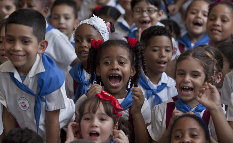 Young students react during a celebration to mark the anniversaries of the Organization of Cuban Pioneers and of the Union of Communist Youth at the Angela Landa elementary school in Old Havana, Cuba, Friday, April 4, 2014. Cuban schoolchildren are referred to as "pioneers," and the organization was founded in 1961 to encourage the values of education and social responsibility among children and adolescents. (AP Photo/Franklin Reyes)