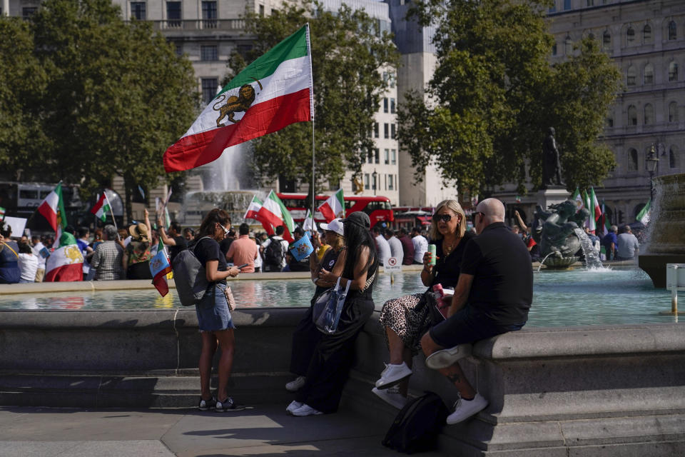 Demonstrators hold flags as they gather in Trafalgar Square, in London, Saturday, Sept. 16, 2023, as today marks the anniversary of the death of Mahsa Amini in Iran. (AP Photo/Alberto Pezzali)