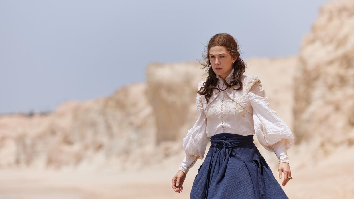  Moiraine in a white shirt and blue skirt channeling the One Power on a beach in The Wheel of Time season 2. 