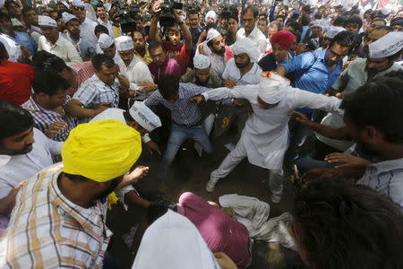 (ATTENTION EDITORS - VISUAL COVERAGE OF SCENES OF DEATH AND INJURY) Protesters gather around a farmer who hung himself from a tree during a rally organized by AAP, in New Delhi April 22, 2015. REUTERS/Adnan Abidi