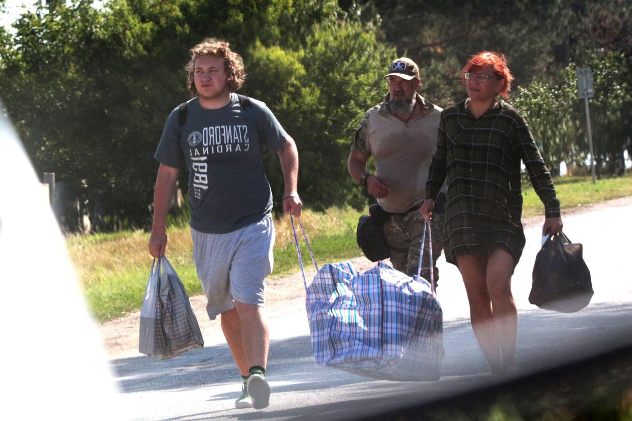 Local residents carry their belongings as they evacuate in the small town of Oktyabr’skoye near Simferopol, on July 22, 2023 (AFP via Getty Images)