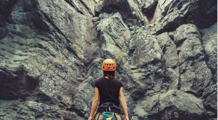 Mountain climber standing in front of a mountain