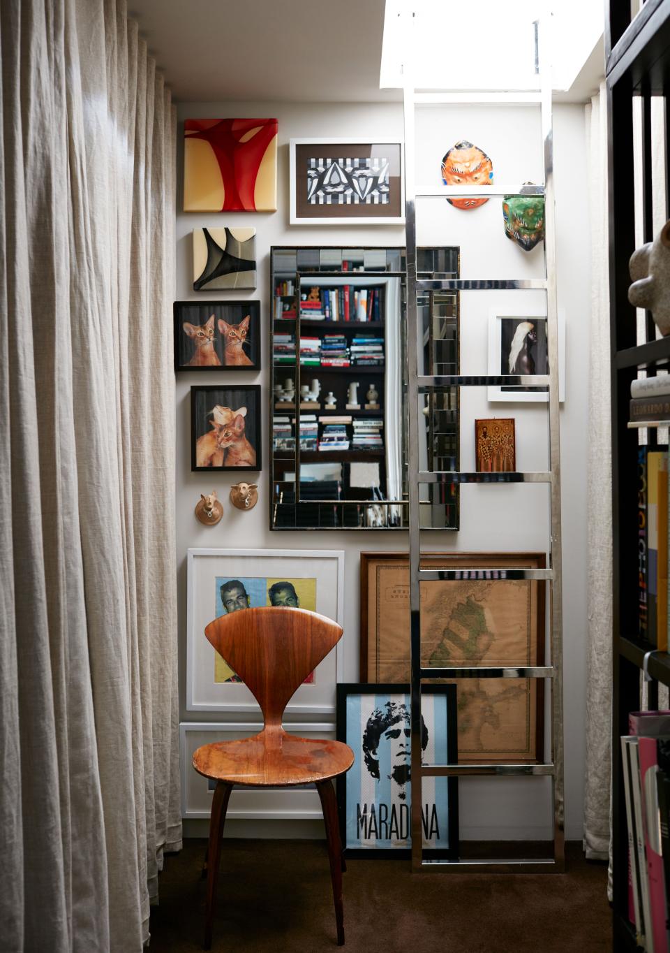 A large walk-in closet features storage and a washer-dryer plus a custom-designed cast-metal ladder that leads up to the small guest bedroom upstairs. The poster of Argentinean soccer icon Maradona was salvaged from the street in New York.