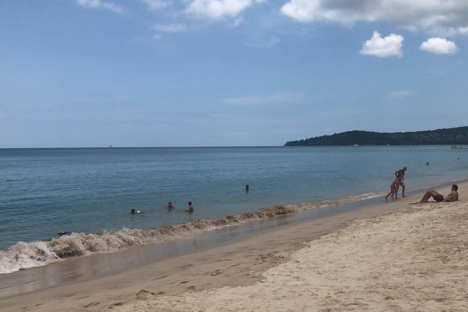 Turistas disfrutan de la playa de Phuket, Tailandia, el 26 de marzo del 2020. Tailandia todavía no cerró sus playas en medio de la pandemia de coronavirus. (AP Photo/Penny Wang)