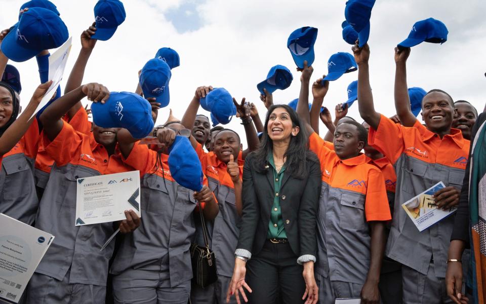 Mrs Braverman with graduate builders in Rwanda who are creating new homes for migrants - Stefan Rousseau/PA 