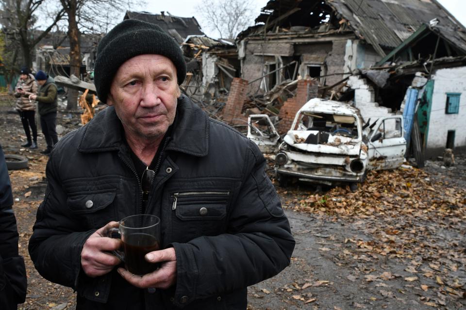 Ivan Kulta, 68, drinks tea next to his destroyed apartment building after Russian shelling in Pokrovsk, Donetsk region (AP)