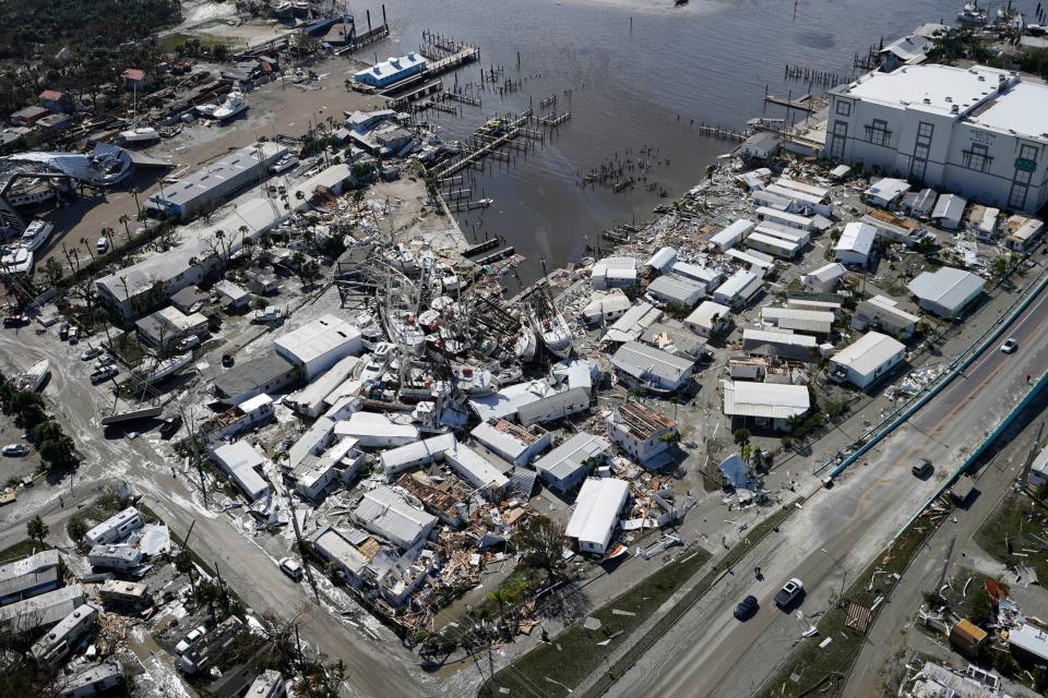 Damages boats lie on the land and water in the aftermath of Hurricane Ian, Thursday, Sept. 29, 2022, in Fort Myers, Fla. (AP Photo/Wilfredo Lee)