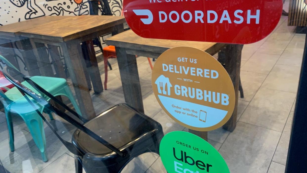 <div>We Deliver, Doordash, Grubhub and Uber Eats signs on restaurant door, New York City. (Photo by: Lindsey Nicholson/UCG/Universal Images Group via Getty Images)</div>