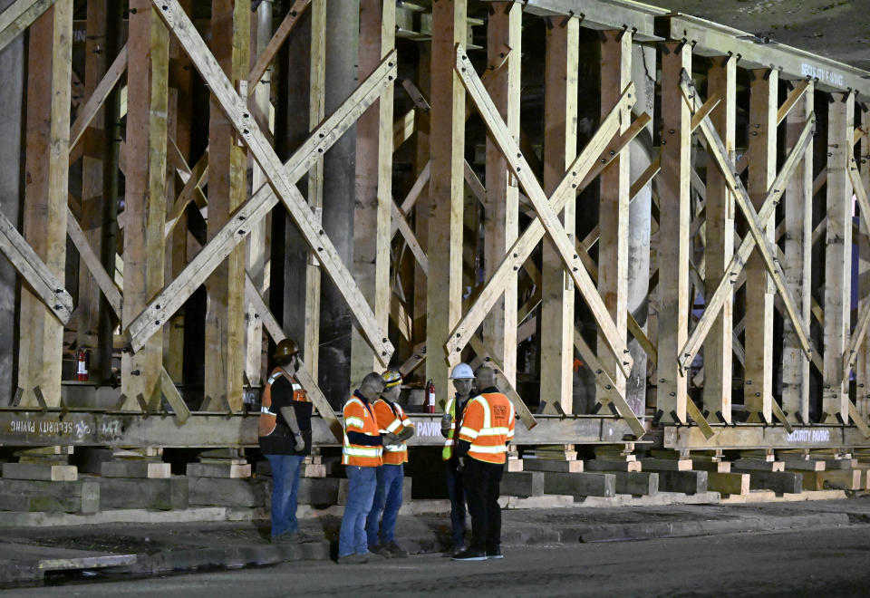 Construction workers gather at the repairs to the I-10 freeway, which was closed by an underpass fire on Saturday, Nov. 11, 2023, in Los Angeles, Sunday, Nov. 19. (AP Photo/Alex Gallardo)